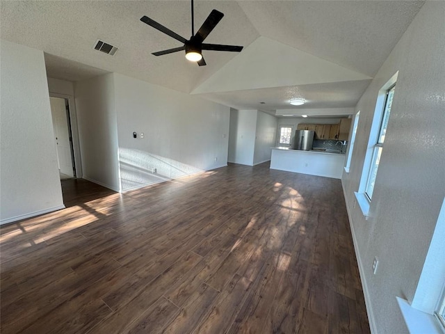 unfurnished living room featuring ceiling fan, dark hardwood / wood-style flooring, high vaulted ceiling, and a textured ceiling