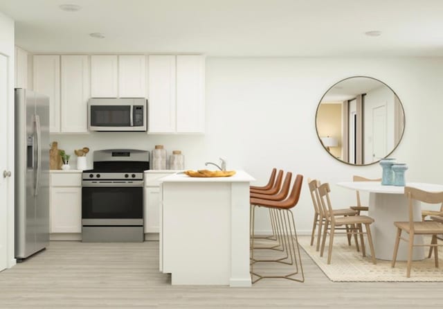 kitchen featuring stainless steel appliances, white cabinetry, and light hardwood / wood-style floors