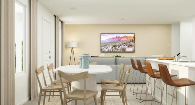 dining space with sink and light hardwood / wood-style flooring