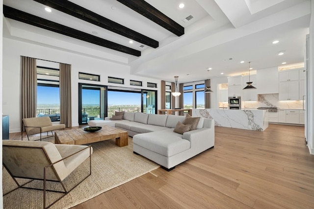 living room with beam ceiling and light hardwood / wood-style flooring