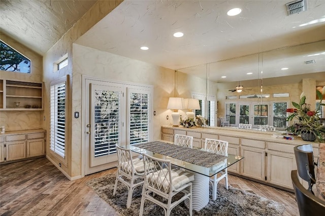 kitchen featuring light brown cabinets, hanging light fixtures, ceiling fan, light wood-type flooring, and kitchen peninsula