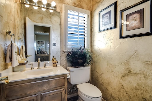 bathroom with a wealth of natural light, vanity, and toilet