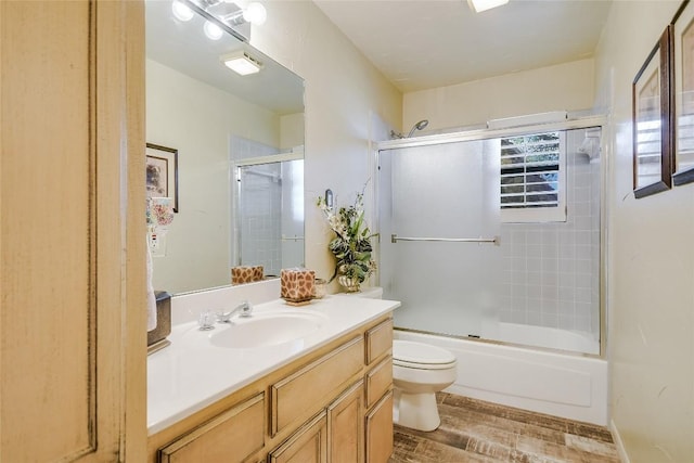 full bathroom featuring shower / bath combination with glass door, wood-type flooring, vanity, and toilet