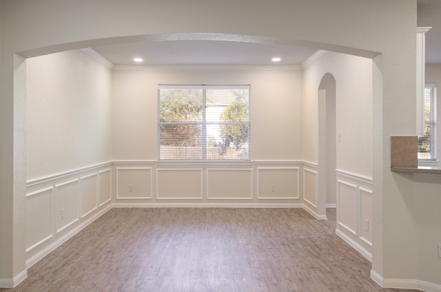 unfurnished room with light wood-type flooring and ornamental molding