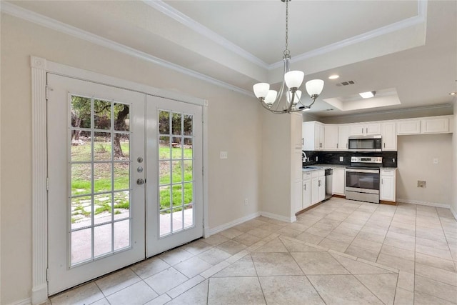 kitchen with appliances with stainless steel finishes, white cabinetry, a raised ceiling, and french doors