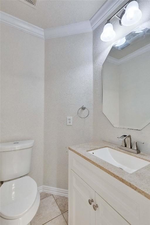 bathroom featuring tile patterned flooring, vanity, toilet, and ornamental molding