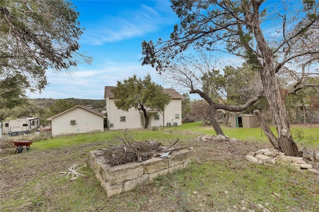 view of yard featuring an outdoor fire pit and a storage shed