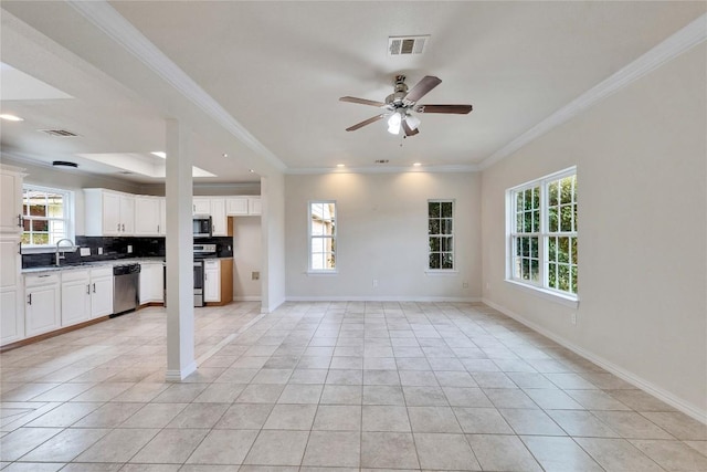 unfurnished living room featuring ceiling fan, sink, light tile patterned flooring, and ornamental molding