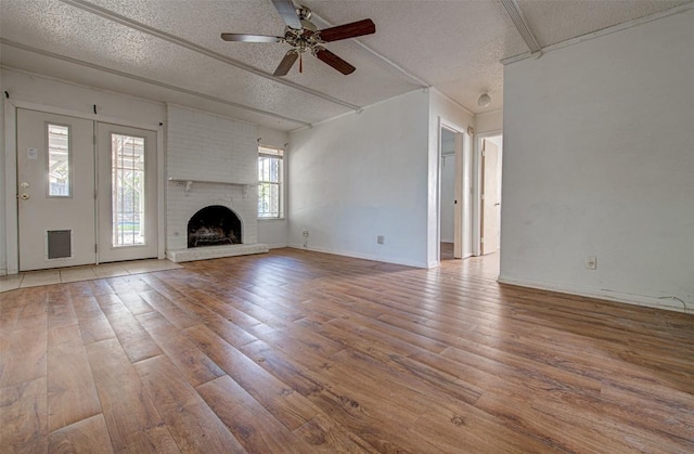 unfurnished living room with a fireplace, hardwood / wood-style floors, a textured ceiling, and ceiling fan