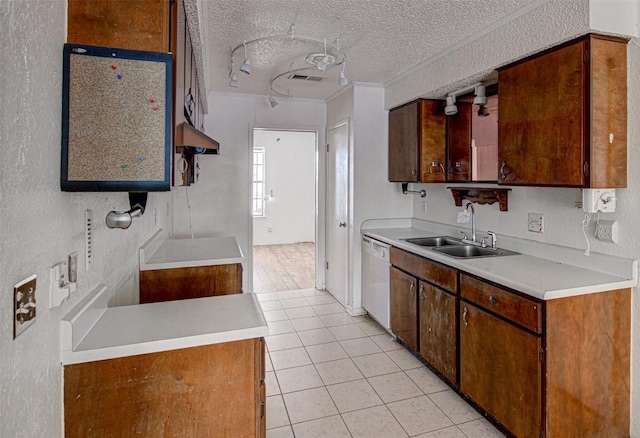 kitchen with white dishwasher, sink, crown molding, a textured ceiling, and light tile patterned flooring