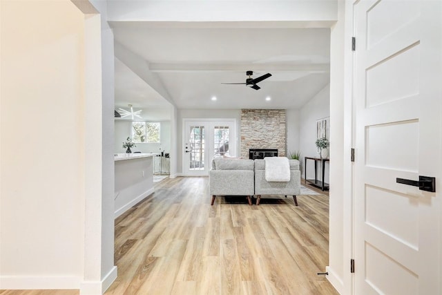 living room with ceiling fan, french doors, vaulted ceiling with beams, light hardwood / wood-style floors, and a fireplace