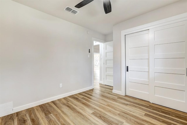 unfurnished bedroom with light hardwood / wood-style flooring, a closet, and ceiling fan