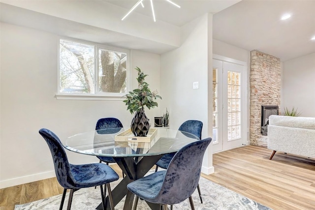 dining space featuring a fireplace and hardwood / wood-style flooring