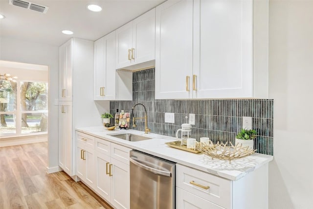 kitchen featuring backsplash, white cabinets, sink, stainless steel dishwasher, and light hardwood / wood-style floors