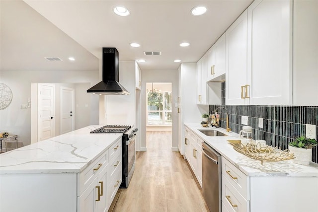 kitchen featuring appliances with stainless steel finishes, backsplash, ventilation hood, light hardwood / wood-style flooring, and white cabinets