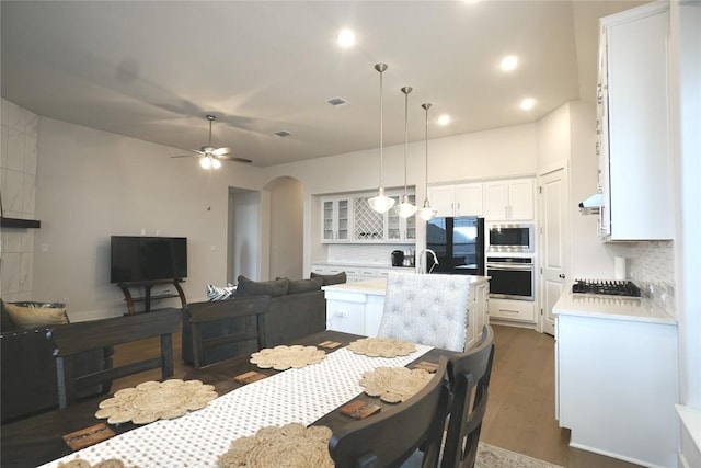 dining area featuring ceiling fan, sink, and dark hardwood / wood-style floors