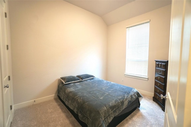 carpeted bedroom featuring multiple windows and lofted ceiling