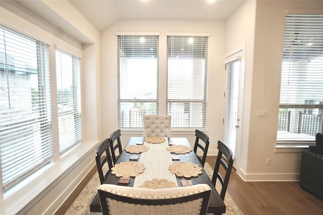 dining space featuring dark wood-type flooring and vaulted ceiling