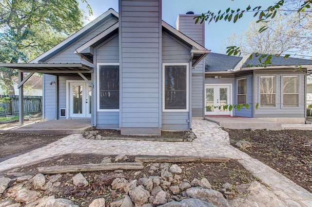 rear view of property with a patio area, french doors, a chimney, and fence