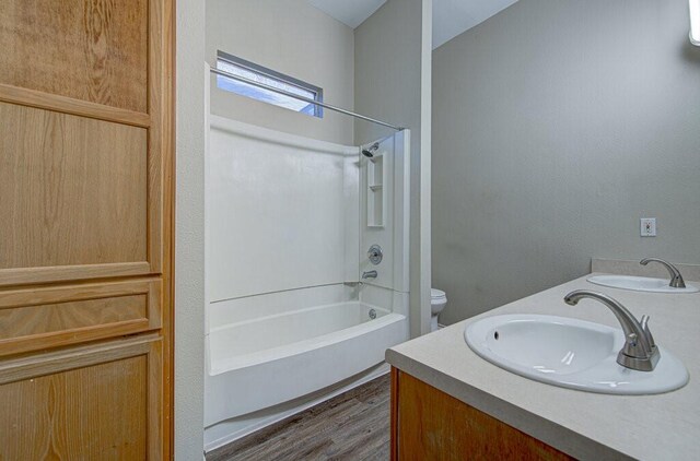 full bathroom featuring hardwood / wood-style floors, vanity, shower / bathtub combination, and toilet