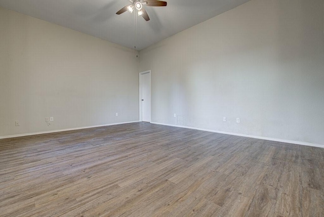 spare room featuring a ceiling fan, wood finished floors, and baseboards