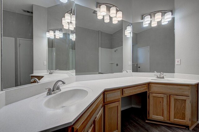 bathroom with hardwood / wood-style floors, vanity, and walk in shower