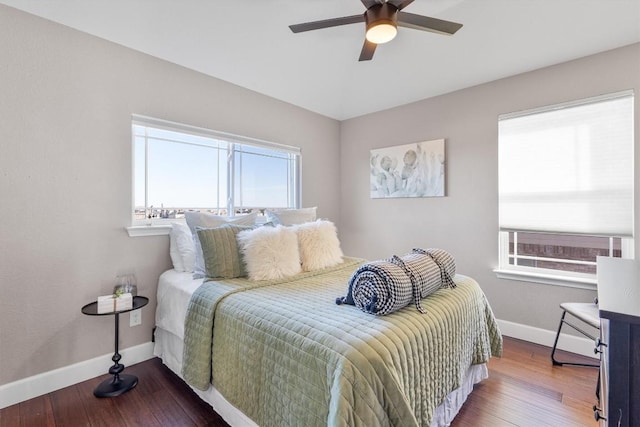 bedroom with multiple windows, ceiling fan, and hardwood / wood-style flooring