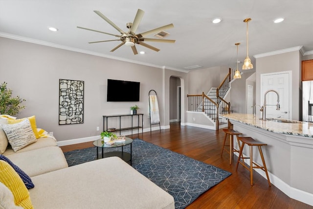 living room featuring ceiling fan, dark hardwood / wood-style flooring, ornamental molding, and sink