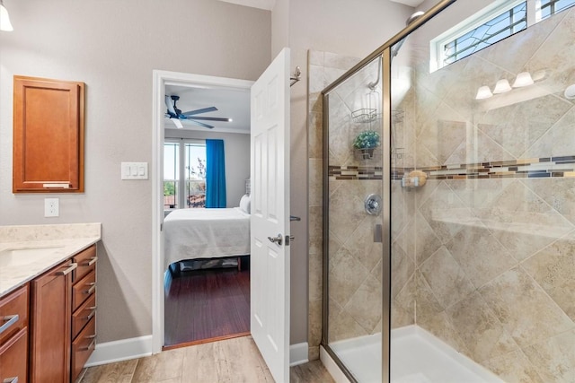 bathroom featuring hardwood / wood-style floors, vanity, ceiling fan, and a shower with shower door