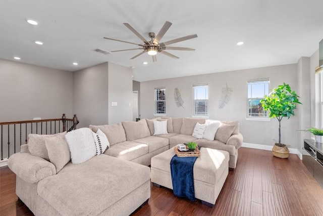 living room featuring ceiling fan and dark wood-type flooring