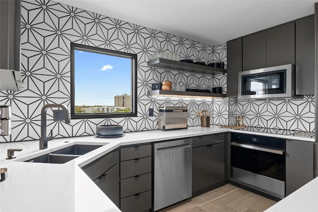 kitchen with stainless steel appliances, sink, and light wood-type flooring