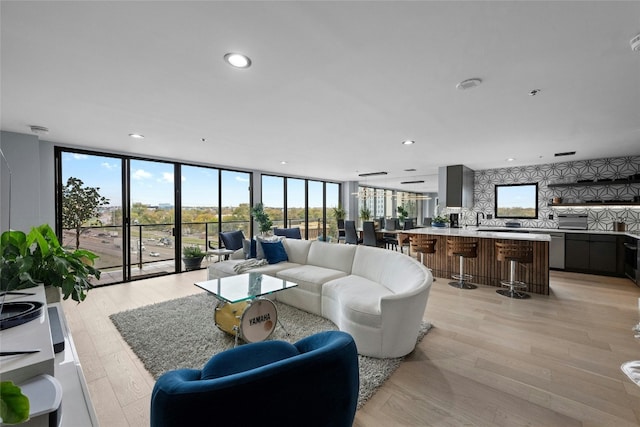 living room with floor to ceiling windows and light wood-type flooring