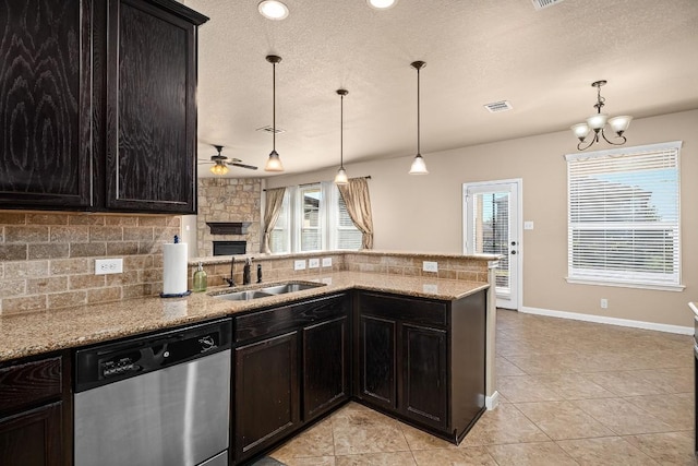 kitchen featuring stainless steel dishwasher, plenty of natural light, pendant lighting, and sink