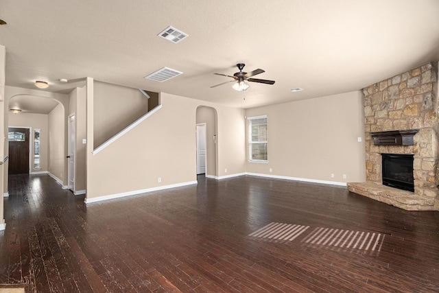 unfurnished living room featuring ceiling fan, dark hardwood / wood-style flooring, and a fireplace