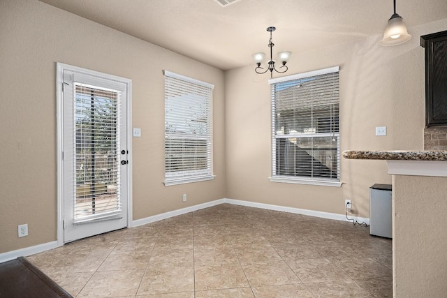 unfurnished dining area with light tile patterned floors and an inviting chandelier