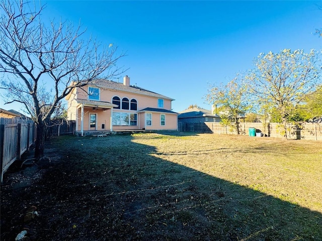 back of property featuring a yard