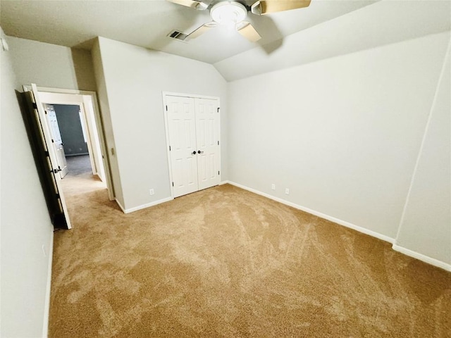 unfurnished bedroom with a closet, light colored carpet, ceiling fan, and lofted ceiling