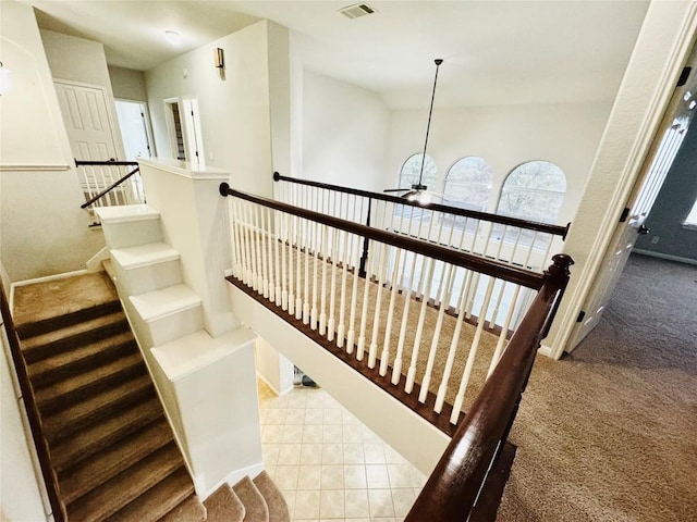 stairway with carpet floors, vaulted ceiling, and ceiling fan