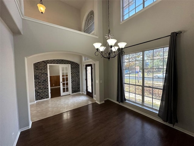 interior space featuring hardwood / wood-style floors, a high ceiling, and an inviting chandelier