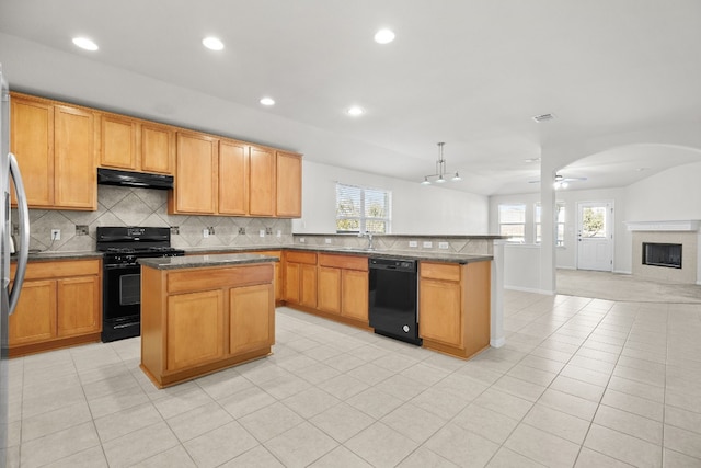 kitchen featuring a center island, black appliances, and plenty of natural light