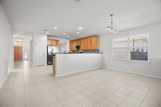 kitchen featuring kitchen peninsula, stainless steel refrigerator with ice dispenser, tasteful backsplash, pendant lighting, and light tile patterned flooring