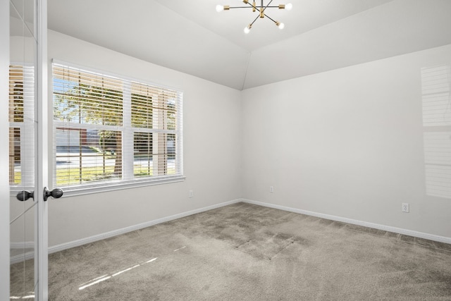 carpeted empty room featuring vaulted ceiling and an inviting chandelier