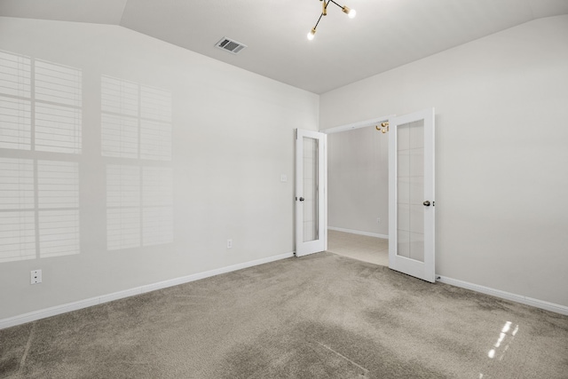 empty room with french doors, carpet, and lofted ceiling