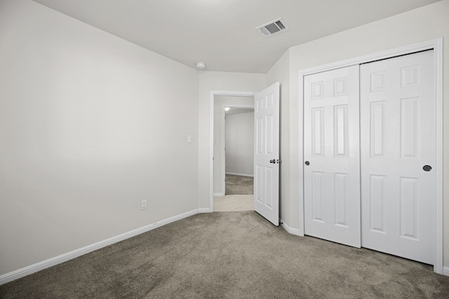 unfurnished bedroom featuring light carpet and a closet