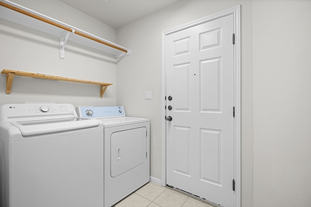 laundry room featuring washer and dryer and light tile patterned floors