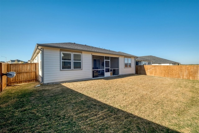 rear view of property featuring a lawn