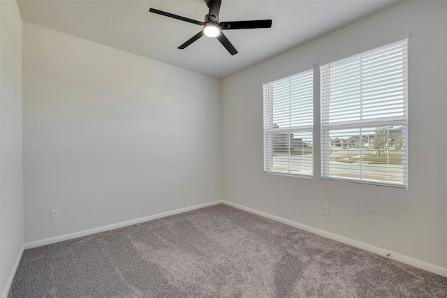 carpeted spare room featuring ceiling fan