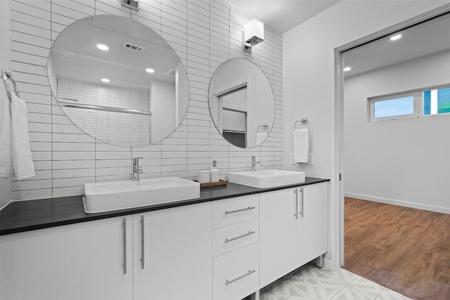 bathroom with tile walls, vanity, decorative backsplash, and hardwood / wood-style floors