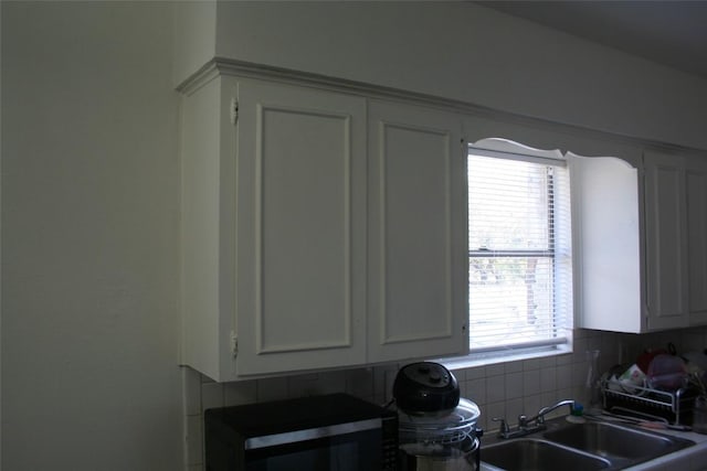 kitchen featuring white cabinets, plenty of natural light, and sink