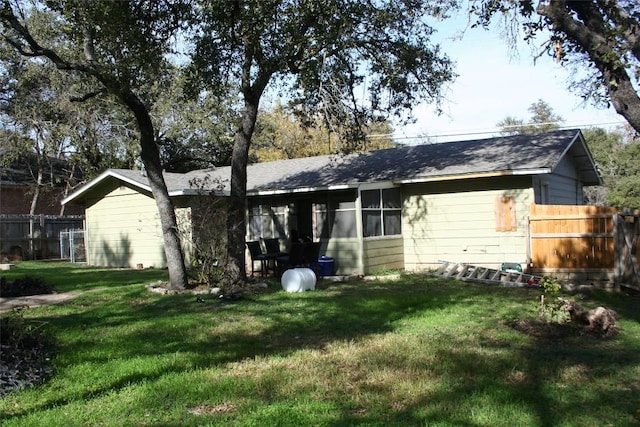 rear view of house featuring a yard